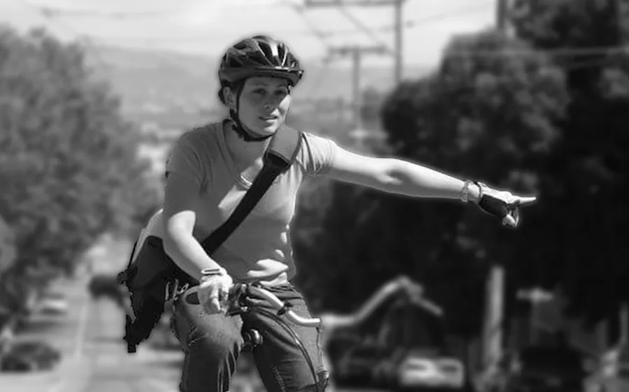 A cyclist signaling a turn by hand