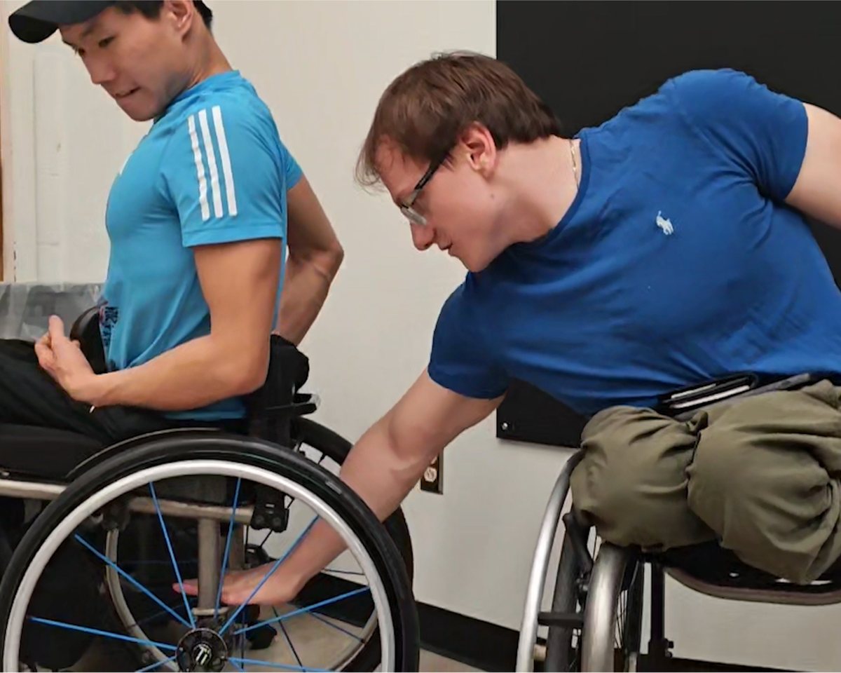 Phillip Croft reaching for the wheel of Leo’s chair