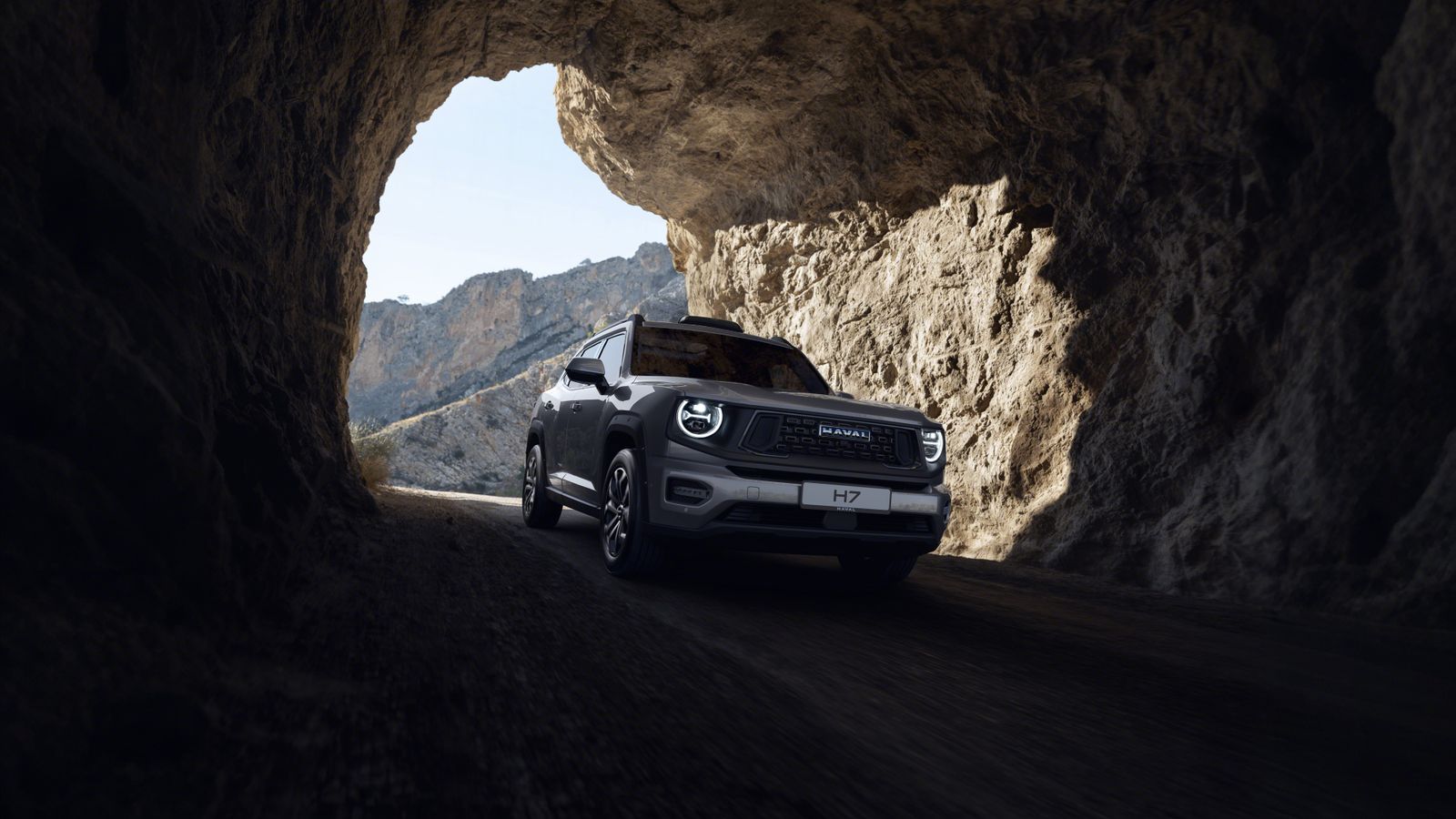 An SUV with UOSON's case on the roof, leaving a rock tunnel